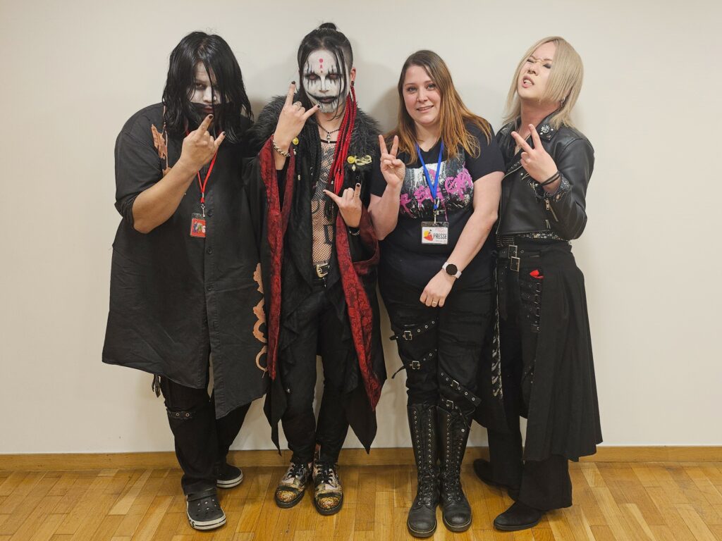 Daiki le bassiste tout à gauche, Keisuke le chanteur en seconde position, Lydie l'intervieweuse ensuite, puis Kay tout à droite.